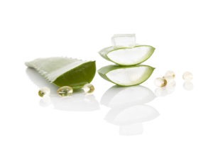 Aloe vera gel caps. Aloe vera sliced leaf and aloe vera gel caps isolated on white background.